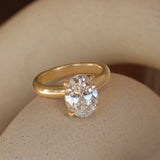 Lifestyle angled view of Noble Ring Oval Lab Diamond 3.02ct by Goldpoint Jewelry on a ceramic with a blurred background