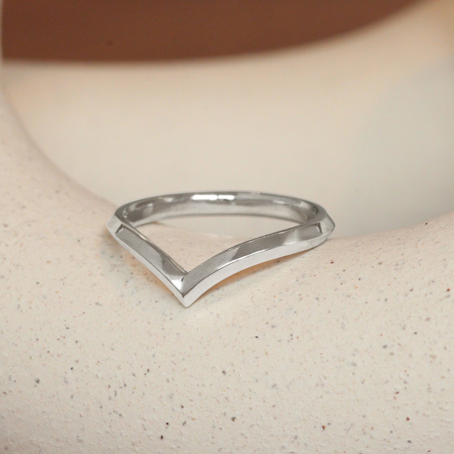 Lifestyle angled view of Peak Knife Edge Band in Platinum by Goldpoint Jewelry on a ceramic