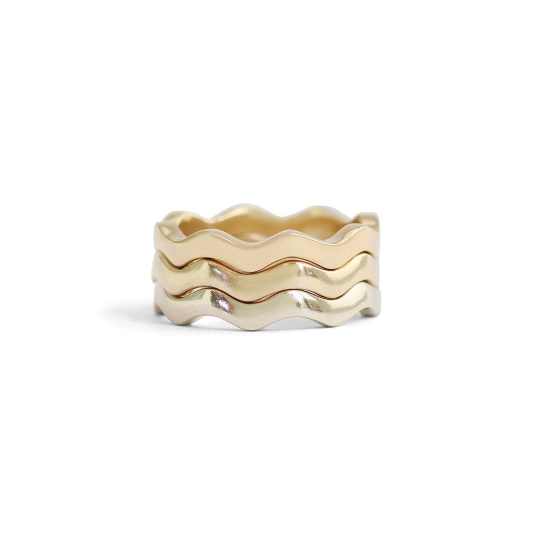 Stacked view of Waves Band in 14k White Gold, Waves Band in 14k Yellow Gold, and Waves Band in 18k Yellow Gold