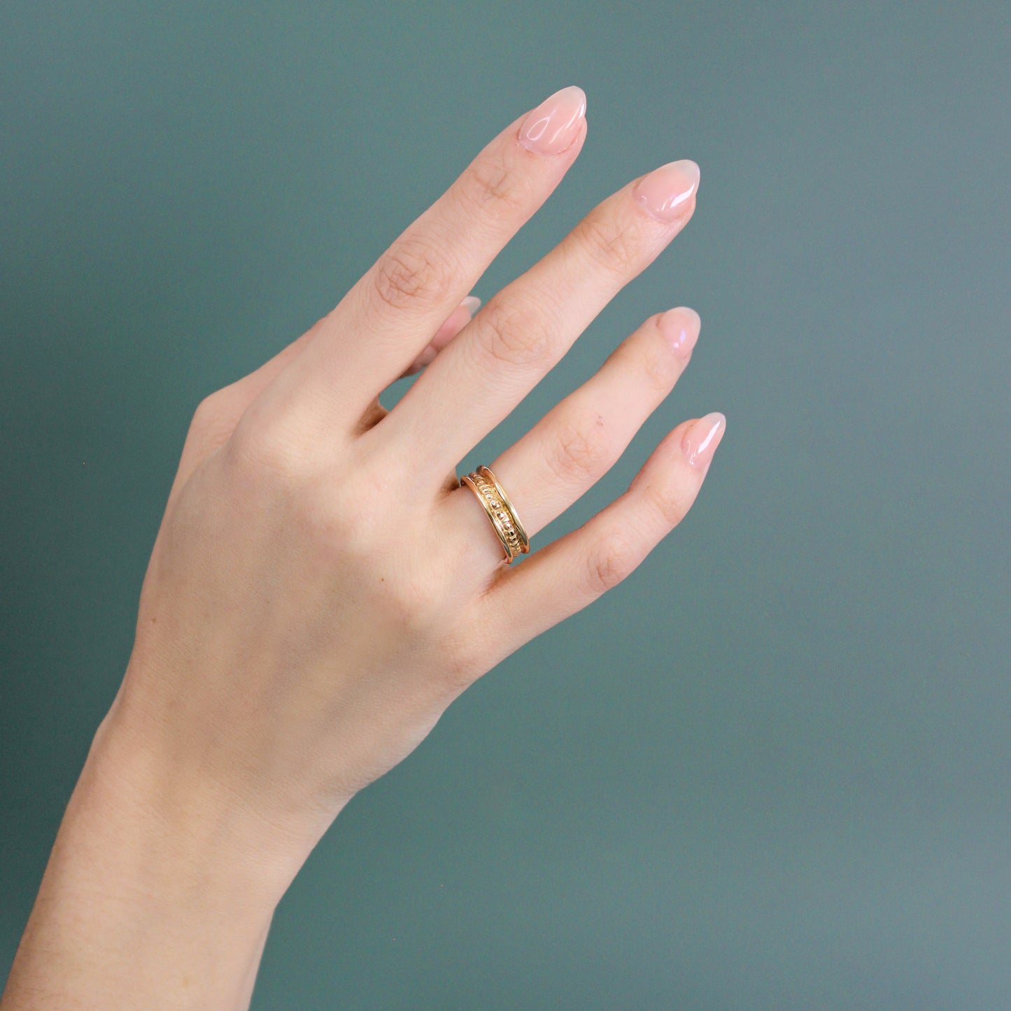 Model wears Ruins Band Polished Sides in 14k yellow gold on ring finger