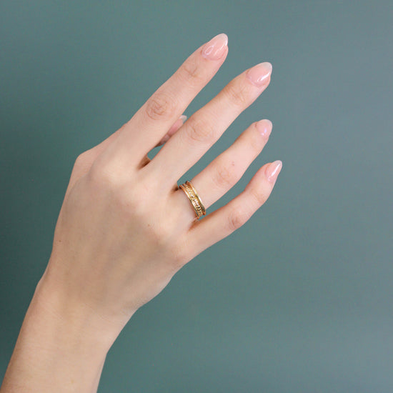 Model wears Ruins Band Polished Sides in 14k yellow gold on ring finger