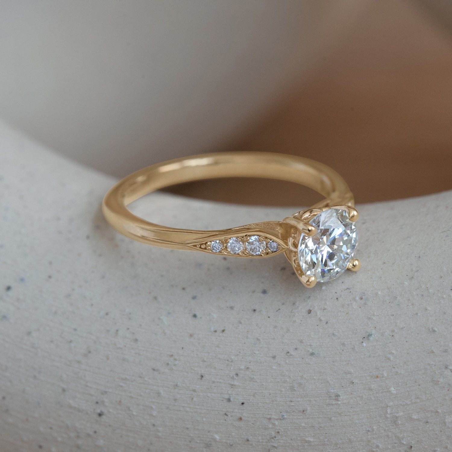 Lifestyle angled side view of Entranced Ring / Round Lab Diamond 0.72ct by Sandy Rubin on a ceramic with a blurred neutral background