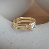 Lifestyle angled side view of Gravitational Pull Ring / Round Lab Diamond 0.75ct by Sandy Rubin on a ceramic with a blurred neutral background