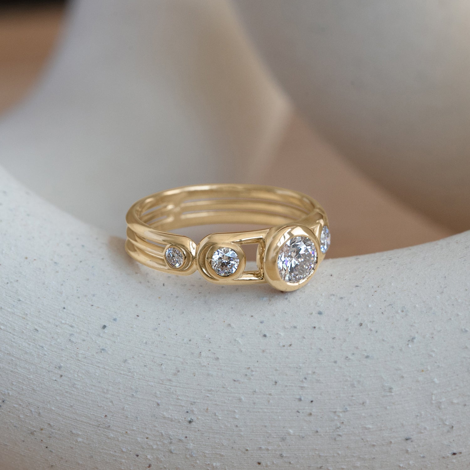 Lifestyle angled side view of Planetarium Ring / Round Lab Diamond 0.50ct by Sandy Rubin on a ceramic with blurred neutral background