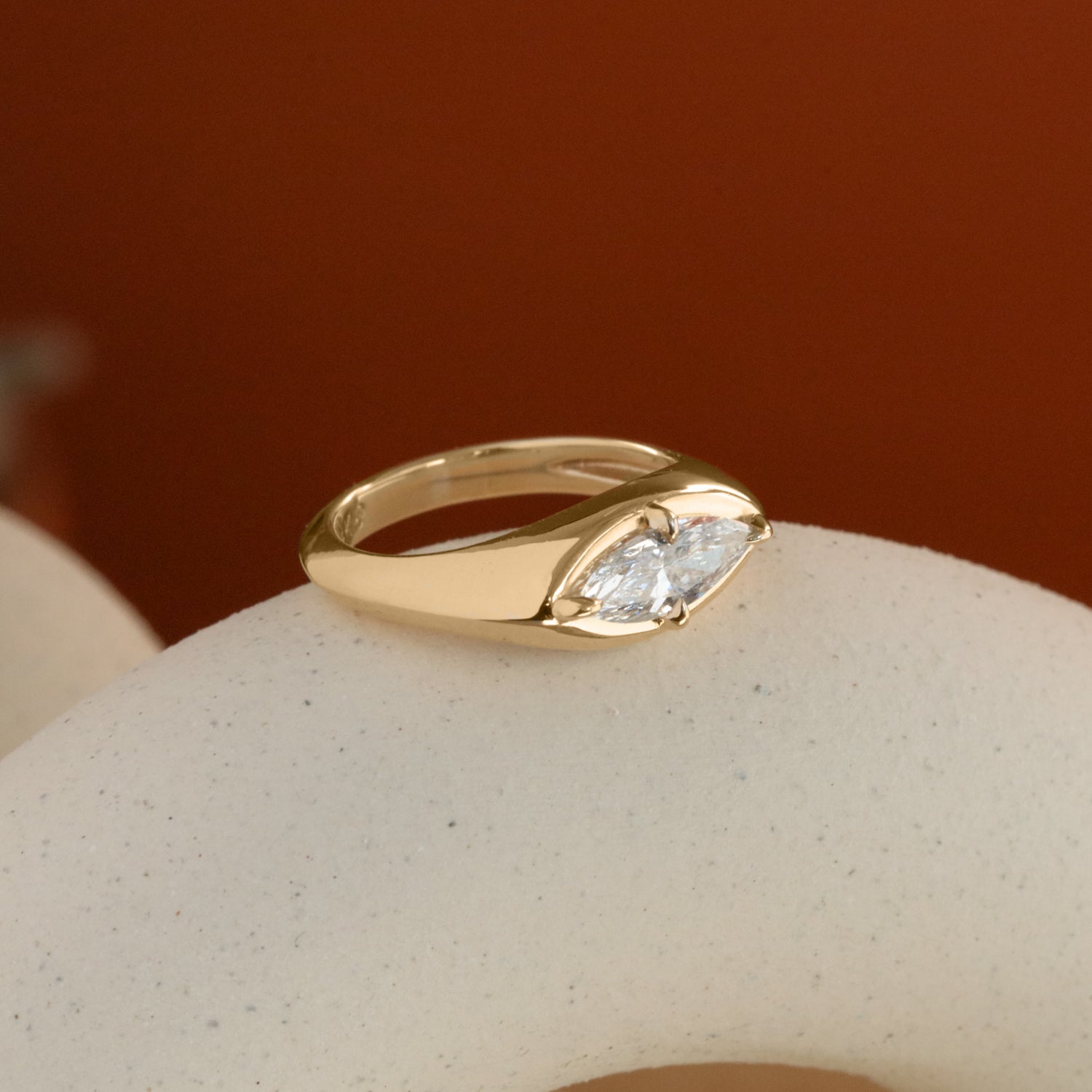 Lifestyle side profile view of Leonard 4 Ring Marquise Diamond 1.02ct by Goldpoint Jewelry on a ceramic with a orange background