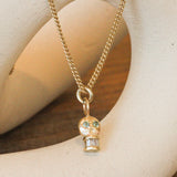 Lifestyle angled side view of Skull Charm / Sapphire Eyes by Oxbow Designs hanging over a ceramic