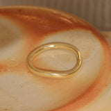 Lifestyle angled view of Flat Band Soft Curve in 14k yellow gold