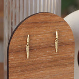 Lifestyle angled view of Spine Drops Earrings by Erin Cuff on a wooden display