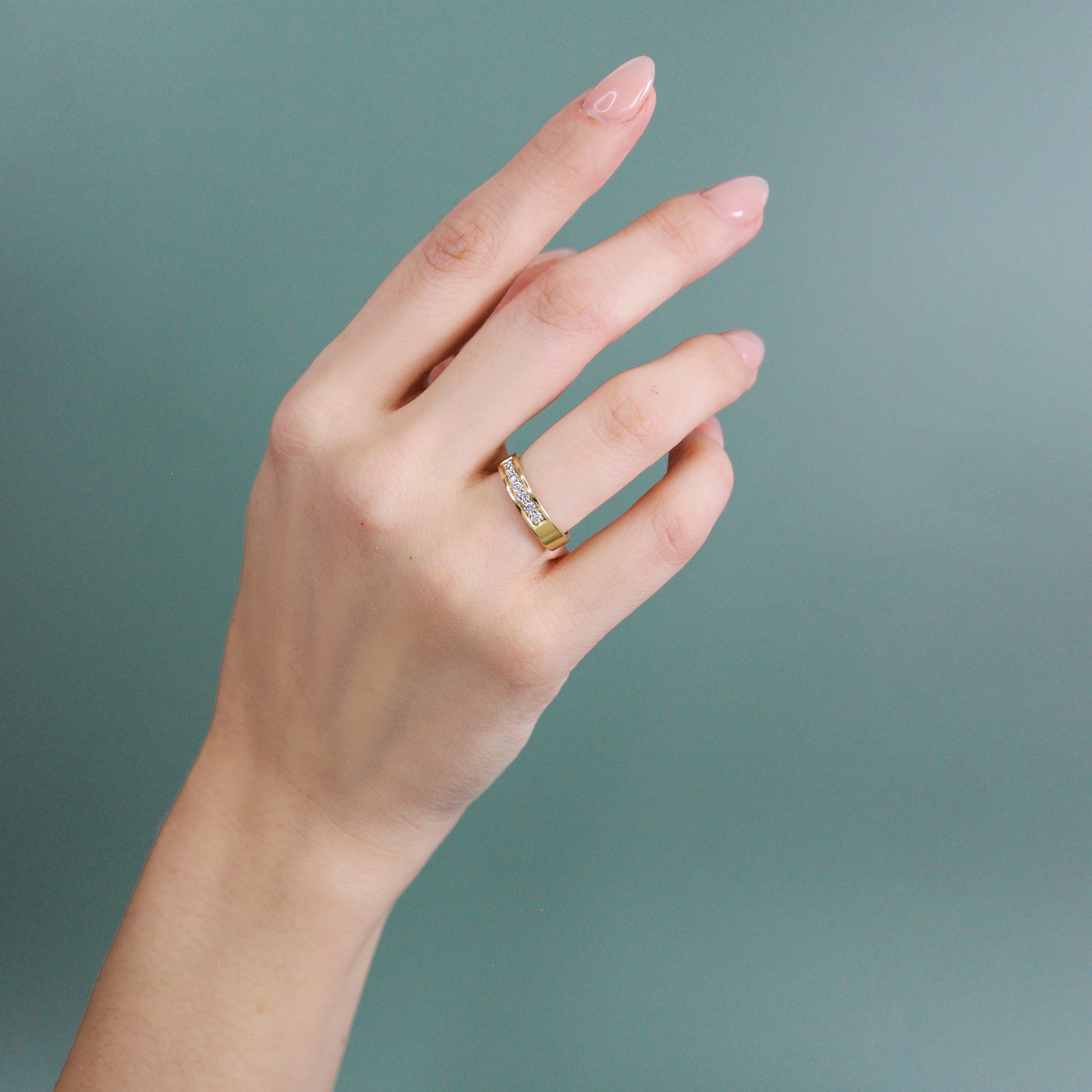 Model wears Flat Band 4mm Bright Cut Lab Diamonds in 14k yellow gold on their ring finger