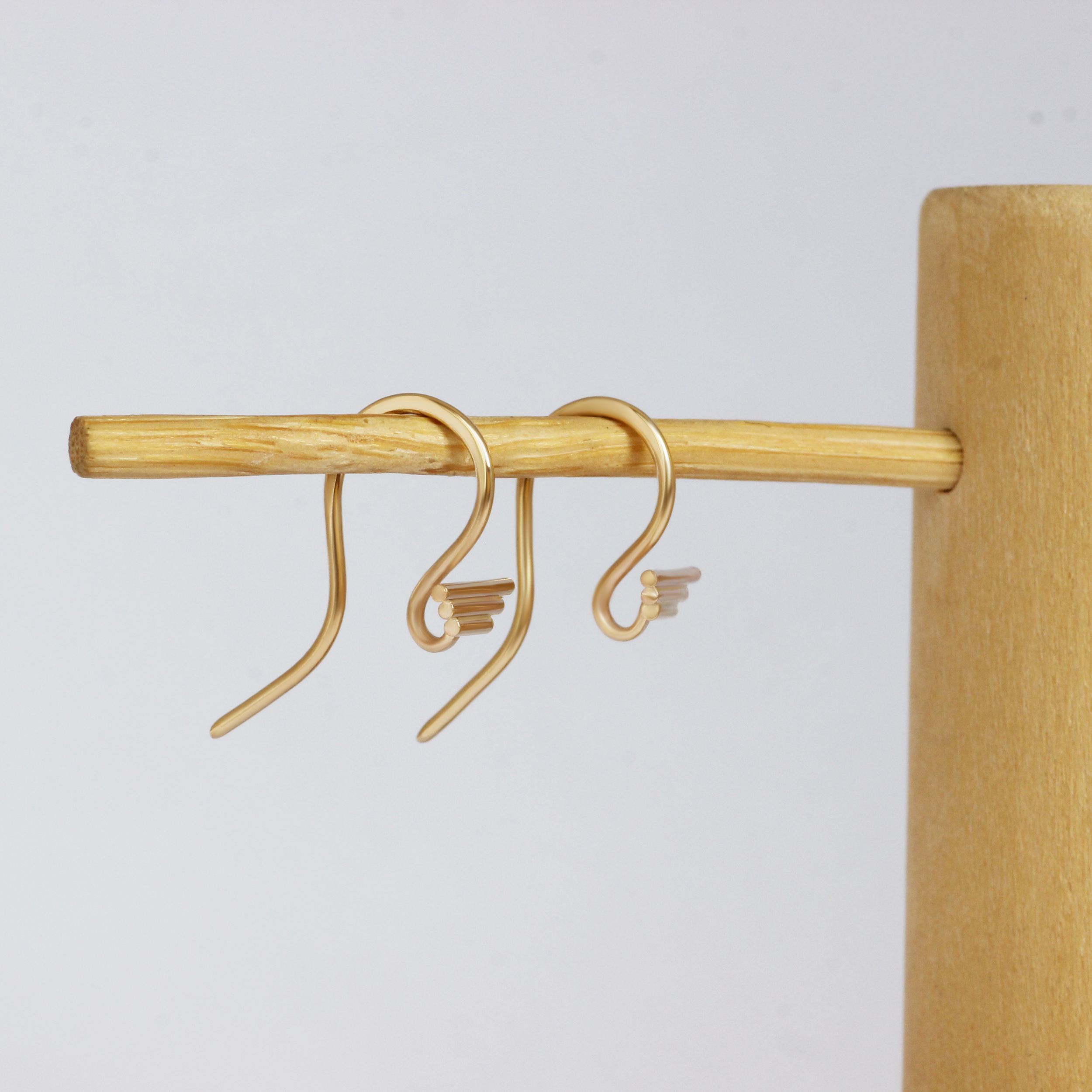 Lifestyle angled view of a set of Step S Hook Earring pieces by Goldpoint Jewelry