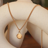 Lifestyle angled view of Step Frame Round Necklace / Curb Chain by Goldpoint Jewelry on a ceramic