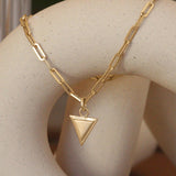 Lifestyle angled view of Step Frame Triangle Bracelet / Paperclip Chain by Goldpoint Jewelry on a ceramic