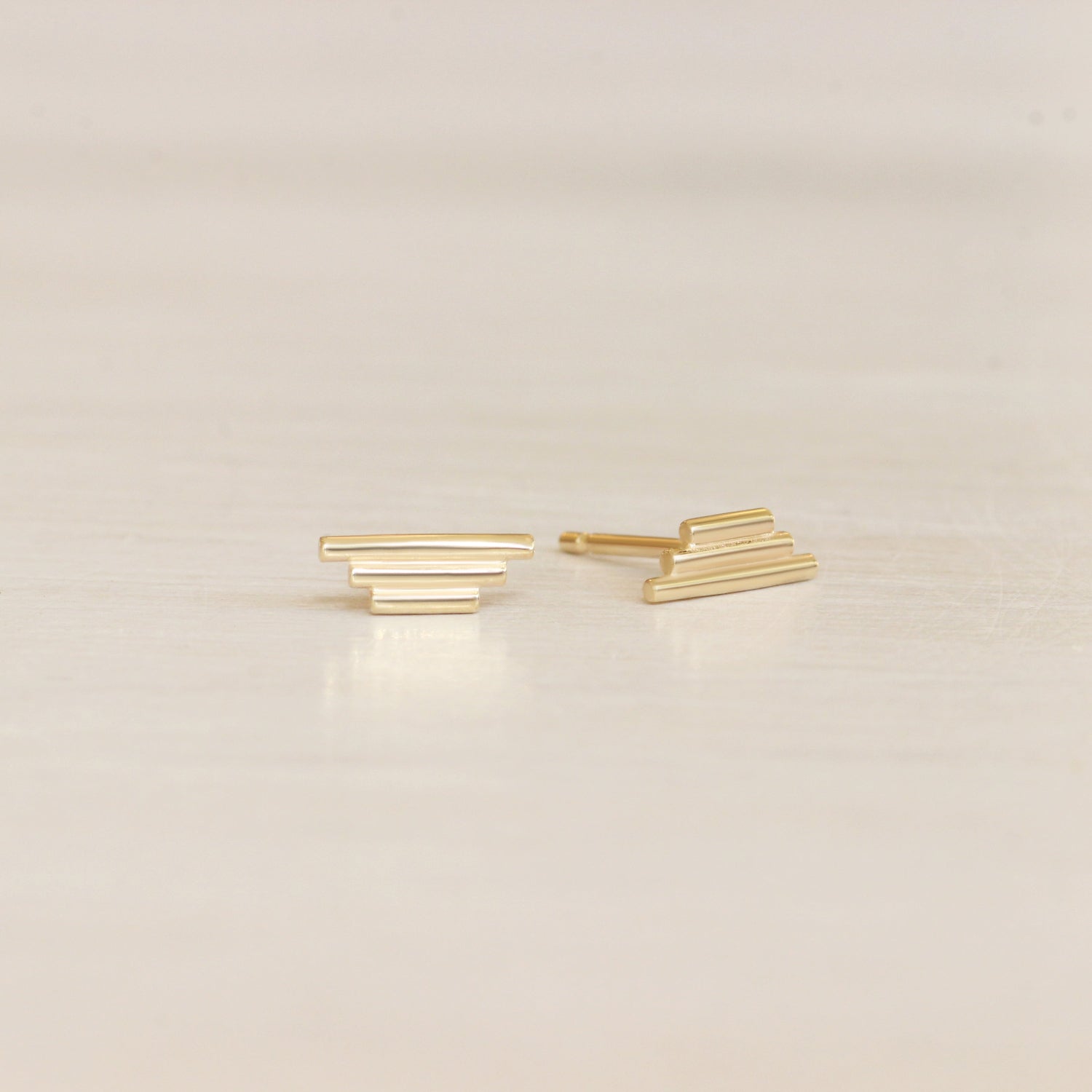 Lifestyle angled view of a set of Step Pyramid Earring pieces by Goldpoint Jewelry