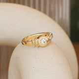 Lifestyle angled view of Step Signet Ring / Round Diamond by Goldpoint Jewelry on a ceramic with a blurred background