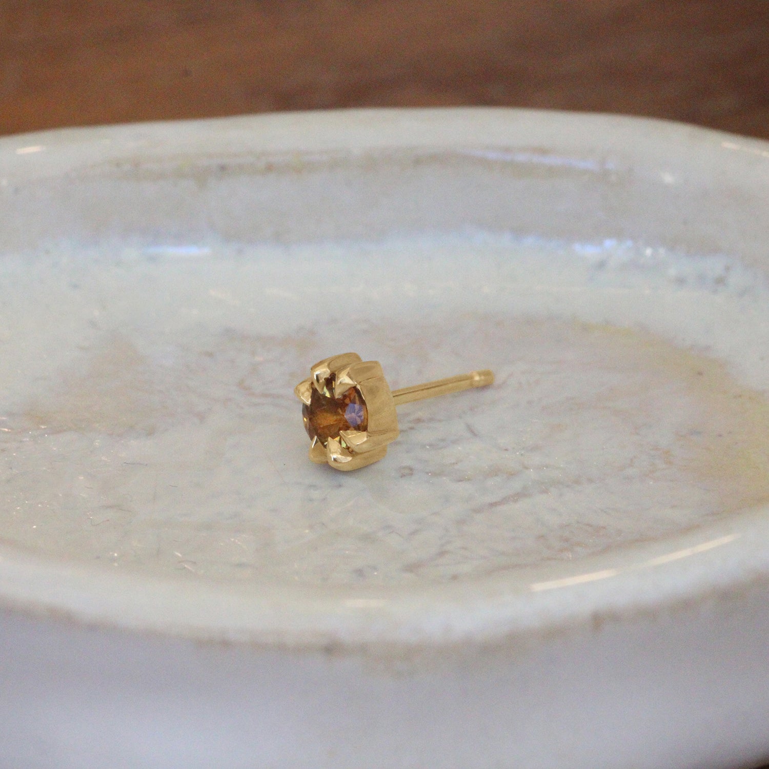 Lifestyle angled view of Talon Earring Round Citrine 4mm by Goldpoint Jewelry on a ceramic