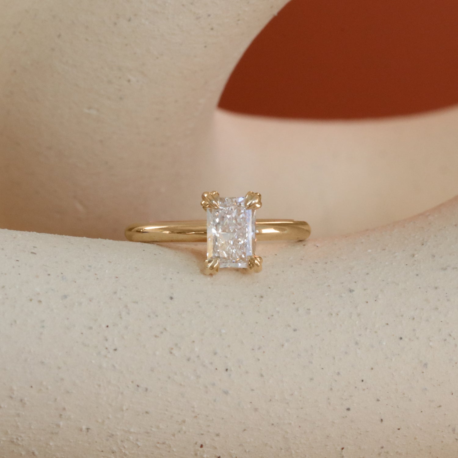 Lifestyle front view of Calyer Ring Radiant Lab Diamond 1ct by Goldpoint Jewelry on a ceramic with orange background