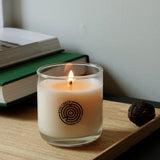Lifestyle view of Wood Cabin Scented Candle by Keap Candles on a shelf with decorative objects