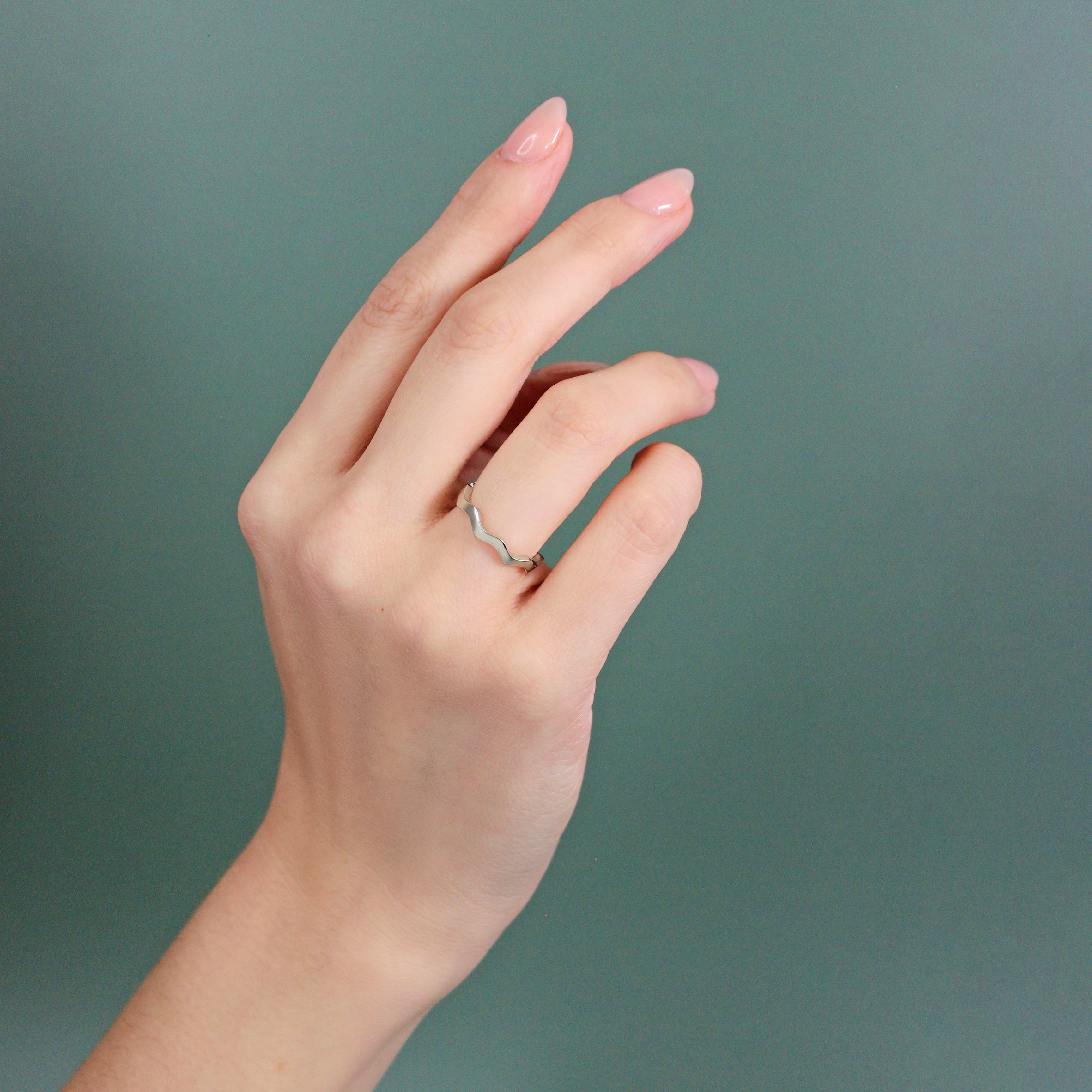 Model wears Waves Band / Thin in 14k white gold on ring finger by Goldpoint