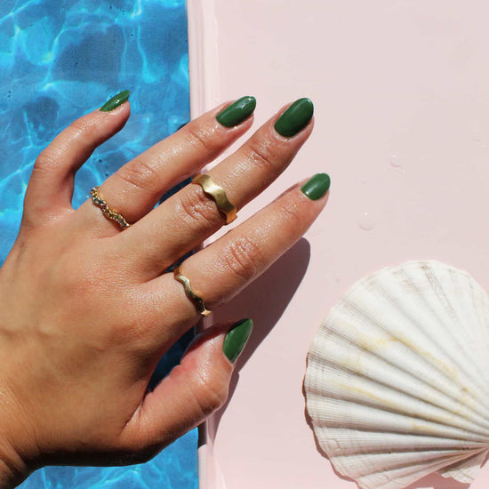 Model wears Waves Band / Wide in 18k yellow gold on middle finger by Goldpoint