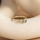 Lifestyle angled view of Wythe Ring Round Sapphire 0.69ct by Goldpoint Jewelry on a ceramic with taupe background