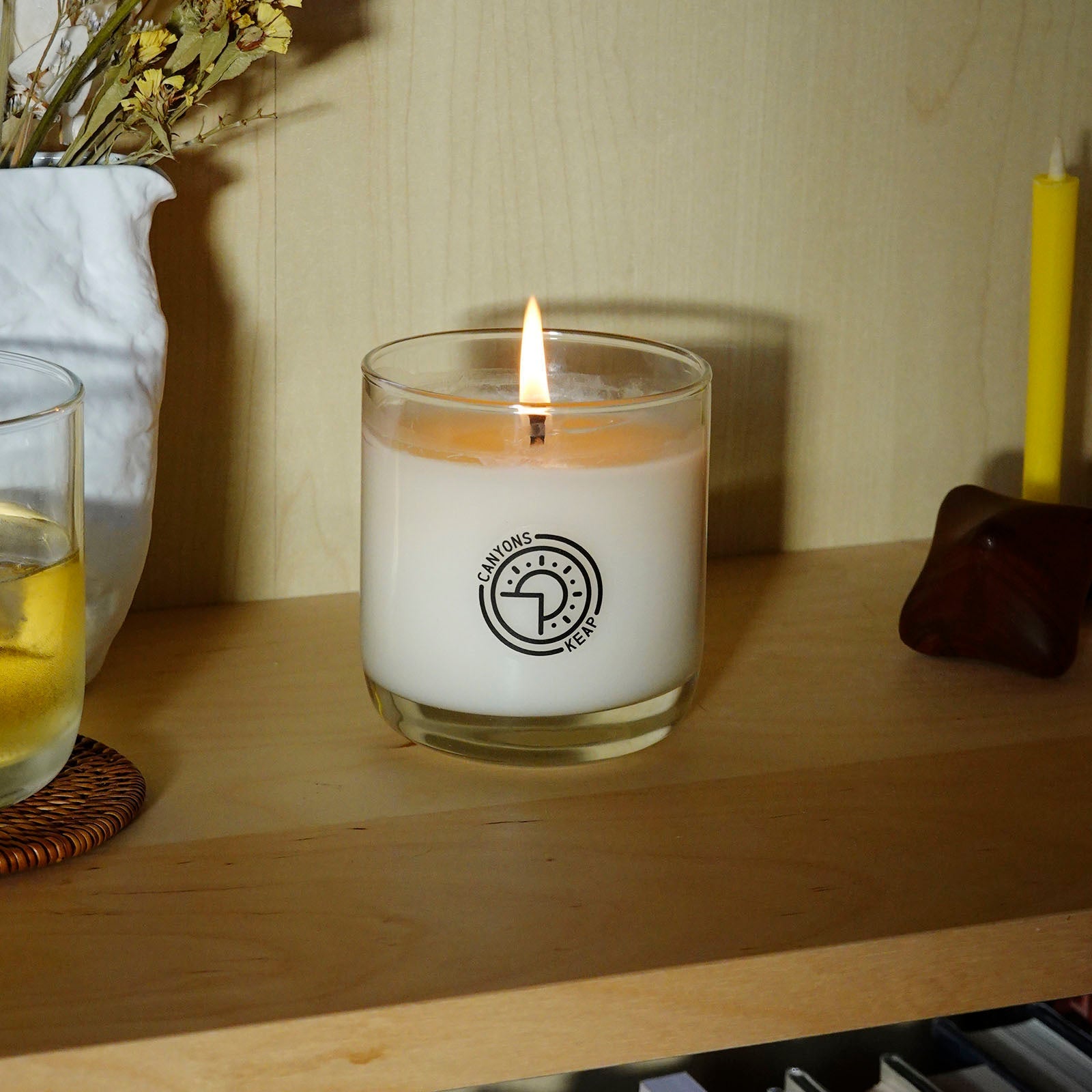 Lifestyle view of Canyons Scented Candle by Keap Candles on a shelf with flowers