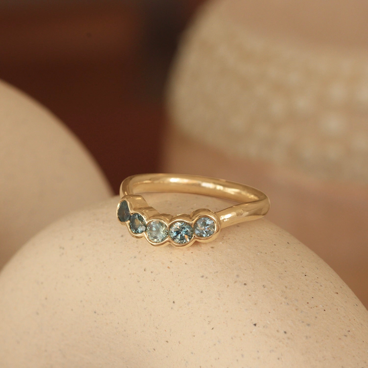 Lifestyle angled view of Cloud 5 Band Curve  Round Sapphires in 18k yellow gold