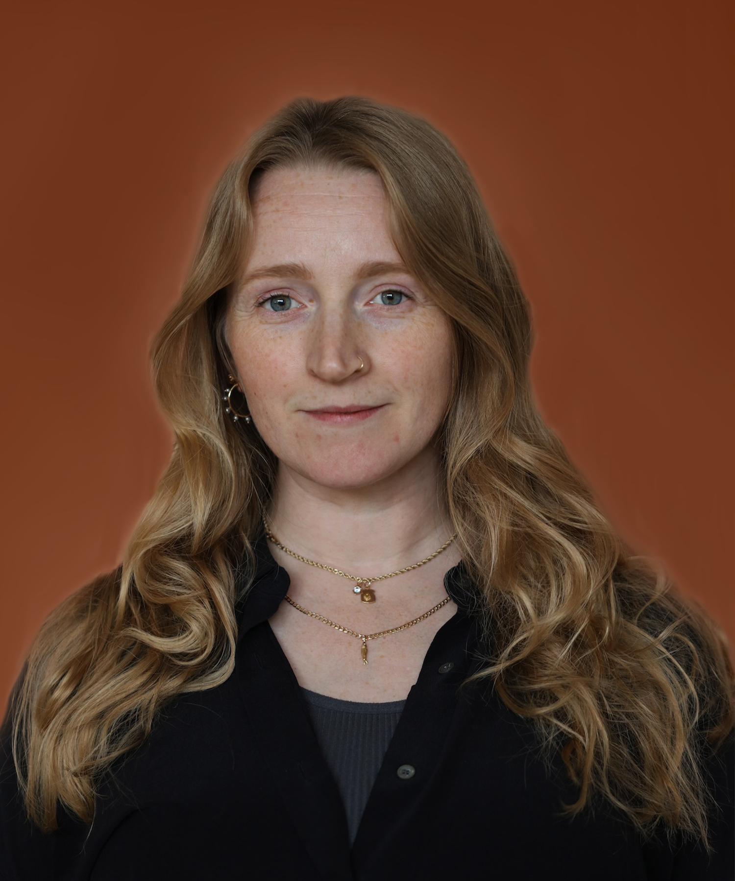 Portrait of Olivia Michaels co-founder of Goldpoint Jewelry on a orange backdrop