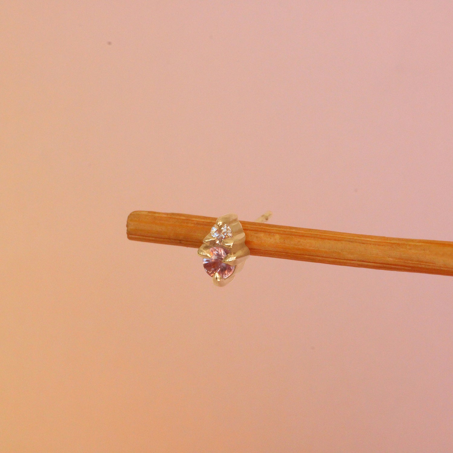 Lifestyle angled view of Points Earring / Ruby & Diamond by Goldpoint Jewelry on a wooden earring display