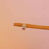 Lifestyle angled view of Points Earring / Ruby & Diamond by Goldpoint Jewelry on a wooden earring display