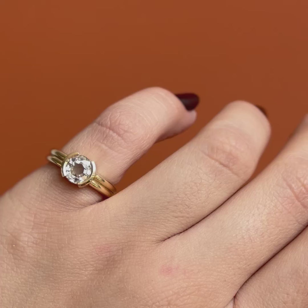 Model wears the Franklin Ring Old Euro Natural Diamond 1.18ct by Goldpoint Jewelry on the pinky finger while showing different views over an orange backdrop