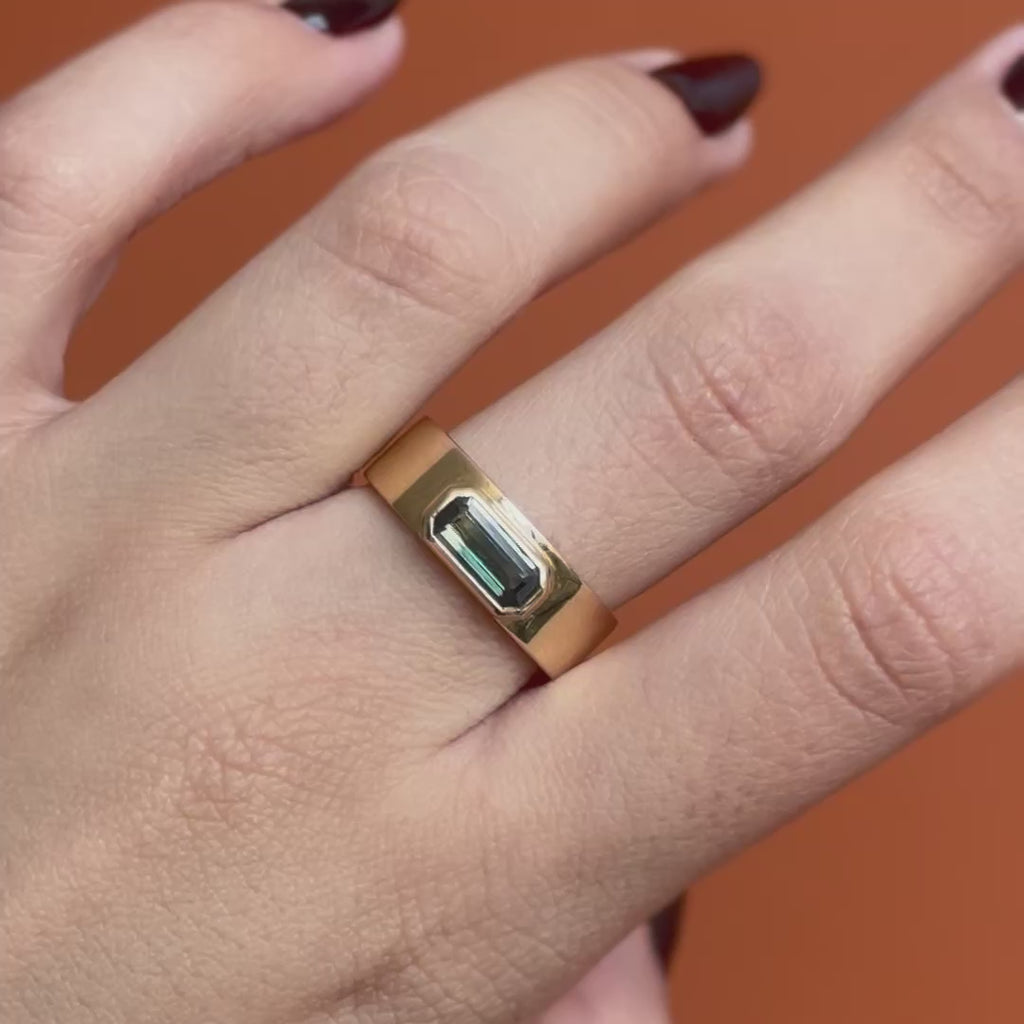 Model wears Kingsland Ring Emerald Cut Sapphire 1.2ct by Goldpoint Jewelry on middle finger showing different angles over an orange backdrop