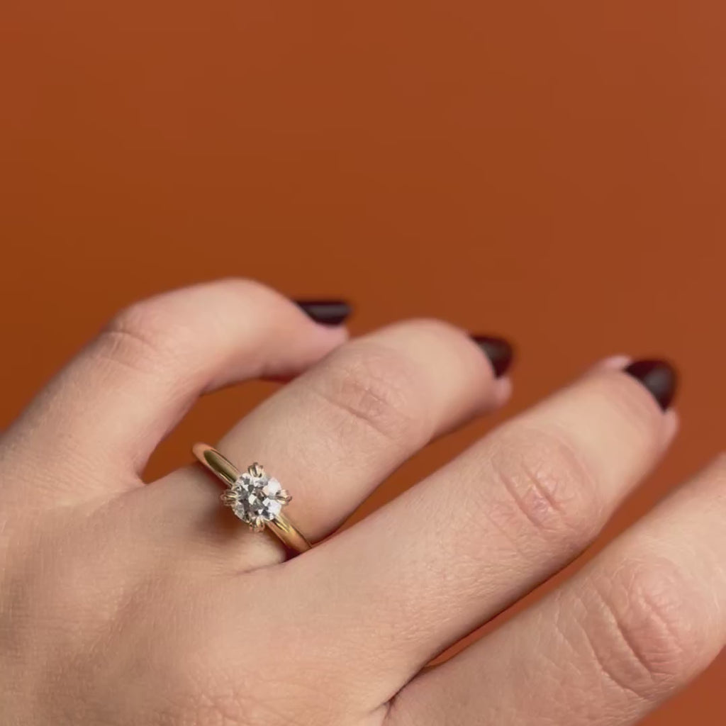 Model wearing Calyer Ring Old Euro Natural Diamond 1.03ct by Goldpoint Jewelry on ring finger showing different angles over a orange backdrop