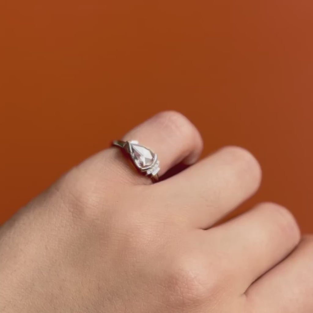 Model wears Kent Ring Pear Lab Diamond 0.62ct by Goldpoint Jewelry on pinky finger showing different angles on an orange backdrop