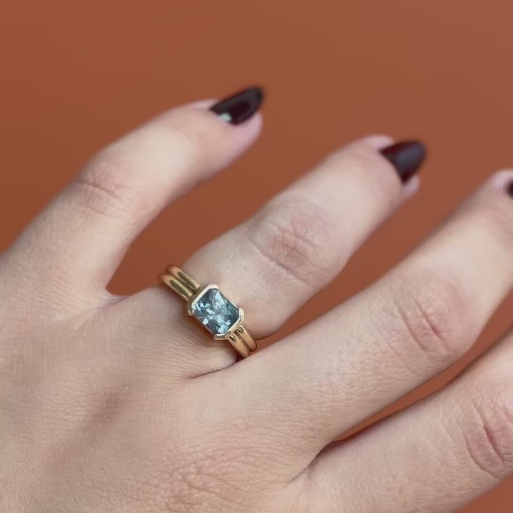 Model wears the Franklin Ring Emerald Cut Sapphire 1.53ct by Goldpoint Jewelry on the ring finger showing different angles over an orange backdrop