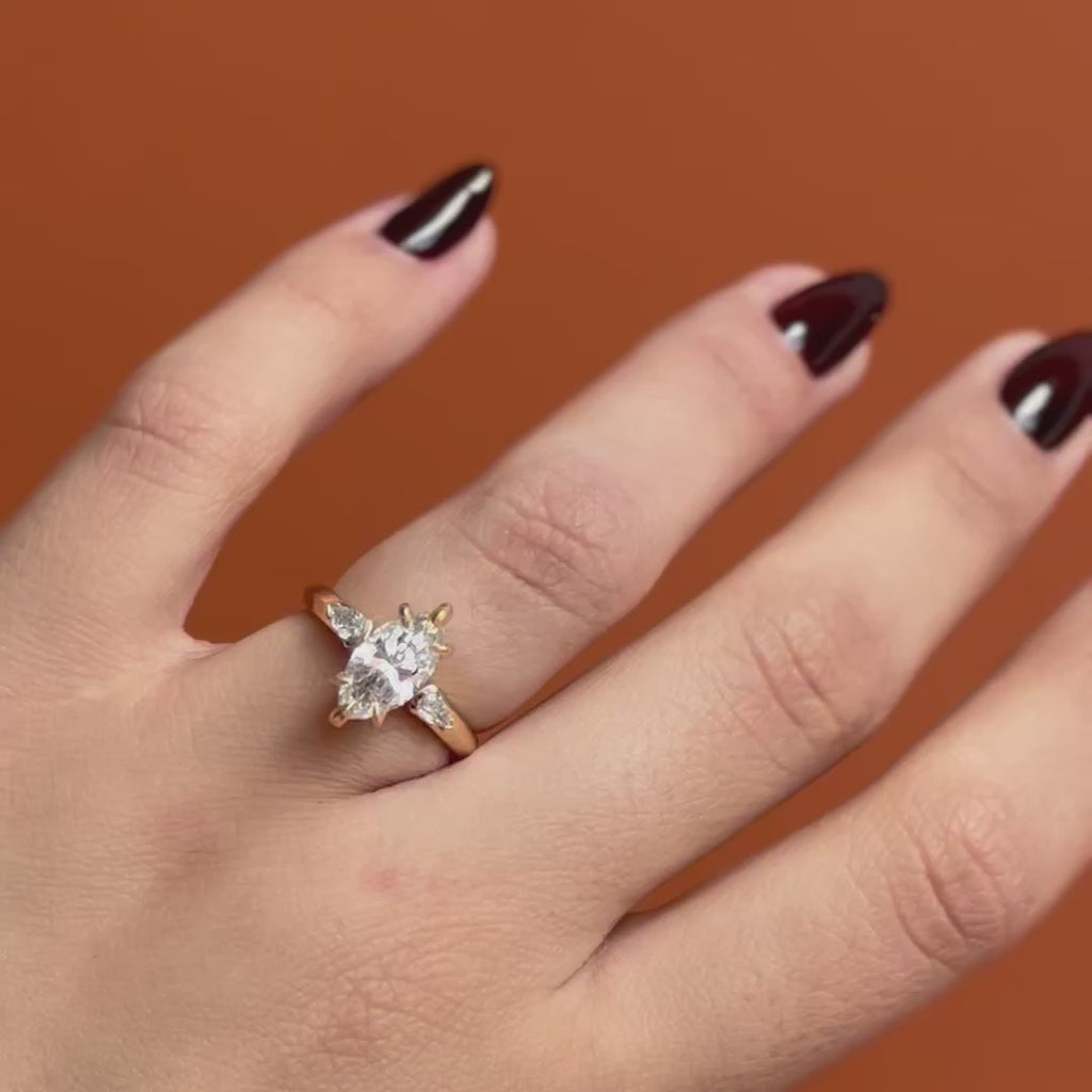 Model wears Wythe Ring Marquise Lab Diamond 1.56ct by Goldpoint Jewelry on the ring finger showing different angles over an orange backdrop