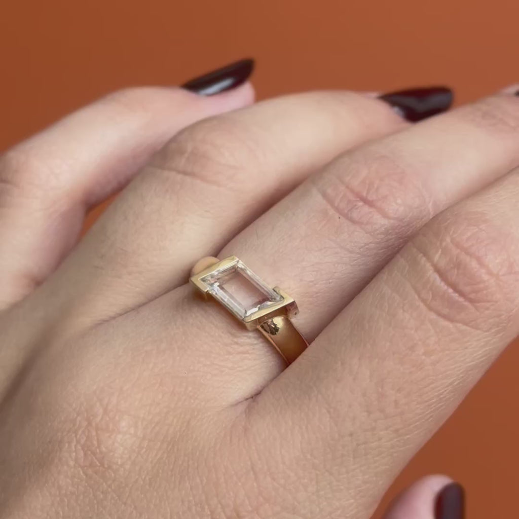 Model wears the Dobbin Ring Portrait Cut Sapphire 1.2ct by Goldpoint Jewelry on middle finger showing different angles on an orange backdrop