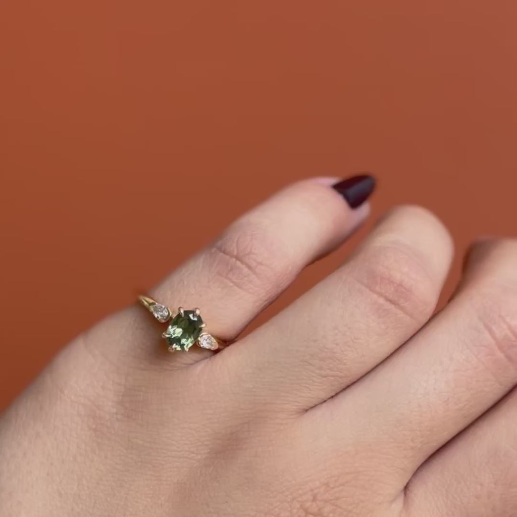 Model wears Wythe Ring Oval Sapphire 1.18ct by Goldpoint Jewelry on pinky finger showing different angles over an orange backdrop