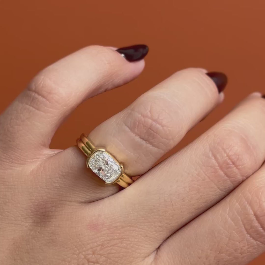 Model wears Franklin Ring Cushion Lab Diamond 2ct by Goldpoint Jewelry on ring finger while showing the different views over an orange backdrop
