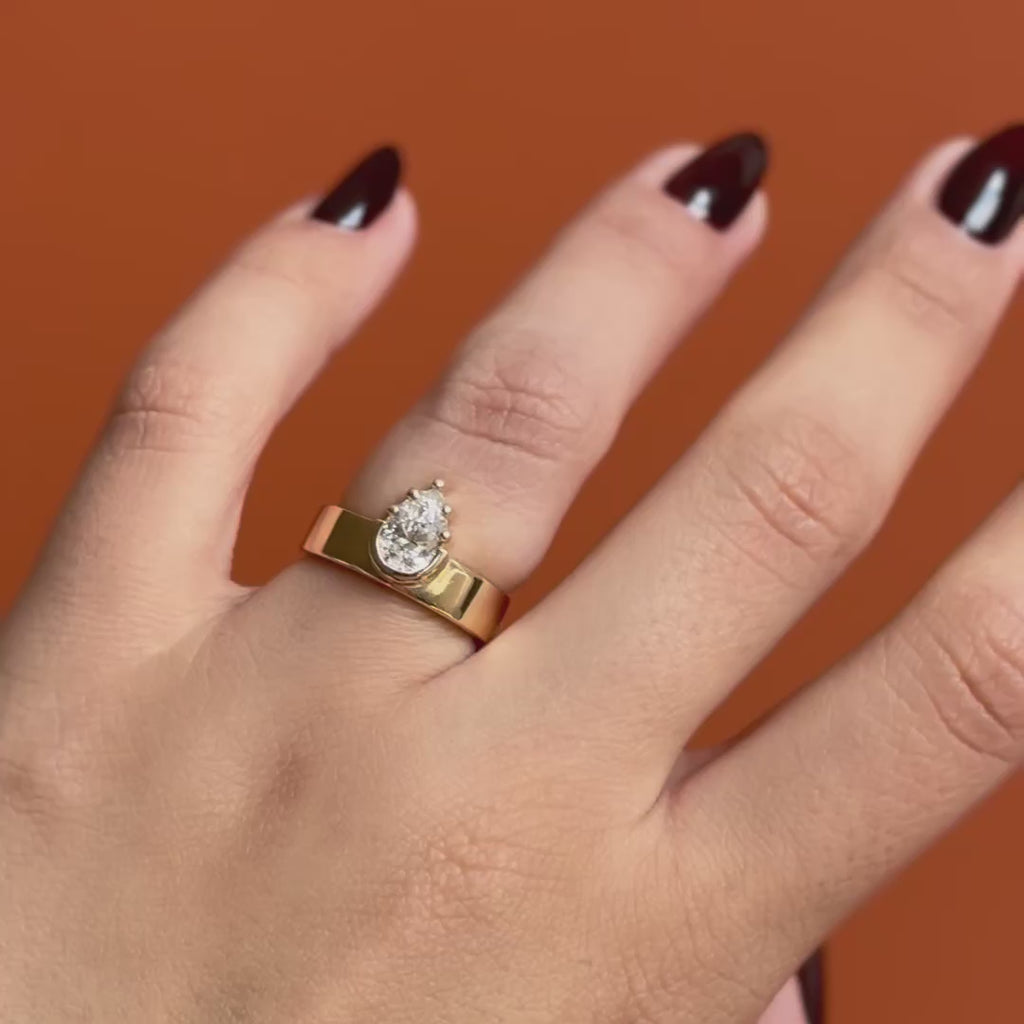 Model wears Varick Ring / Pear Lab Grown Diamond 1.01ct by Goldpoint Jewelry on the ring finger showing different angles over an orange backdrop