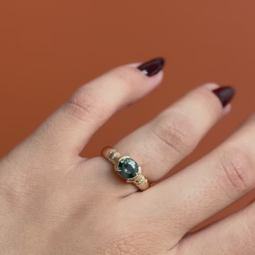 Model wears Dobbin Ring Oval Sapphire 2.01ct by Goldpoint Jewelry on ring finger while showing different angles over an orange backdrop