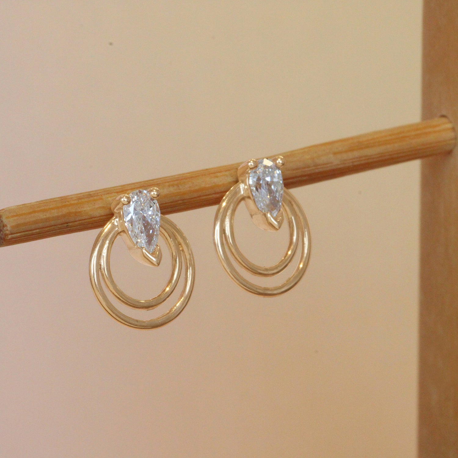 Lifestyle angled view of a set of Ripple Earring / Lab Pear Diamond pieces by Goldpoint Jewelry