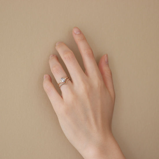 Model wearing Peak Band / Knife Edge stacked with engagement ring