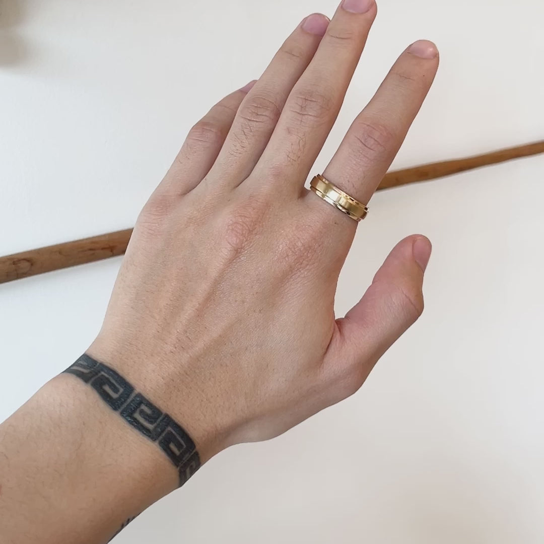 Model wears Cornice Flat Band Wide in 14k yellow gold on their index finger