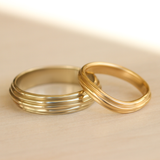 Lifestyle view of Cornice Band Soft Curve in 14k yellow gold stacked with another Cornice Collection bad