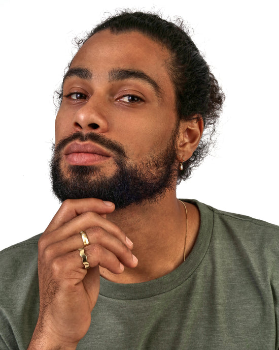 Model wears Waves Band / Wide in 18k yellow gold on pinky finger by Goldpoint