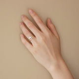 Model wears Waves Band / Thin stacked with an engagement ring on your ring finger by Goldpoint