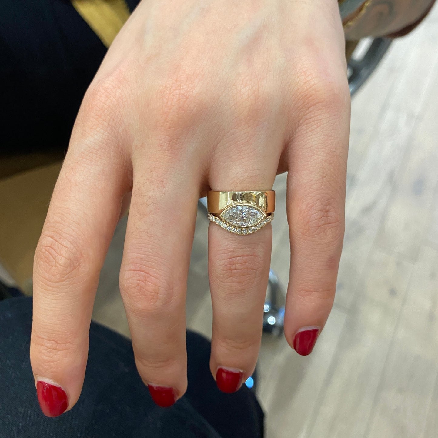 Model wearing Curve Flat Band / Standard + Diamonds + 14k with custom engagement ring on ring finger